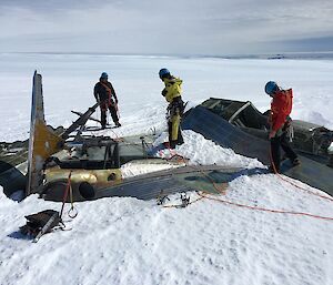 Expeditioners examine the wreck of the Russian aircraft on the snow near Mawson