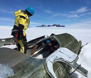 Two expeditioners examine the fuselage of the wrecked aircraft near Mawson