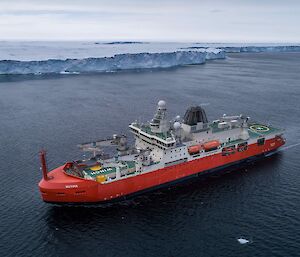 aerial view of ship near ice cliff