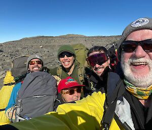 5 people smiling with backpacks on with the Vestfold Hills in the background