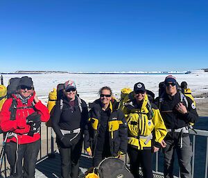 A group of people with backpacks ready for a walk across the snow