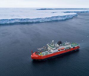ship on ocean near ice cliff