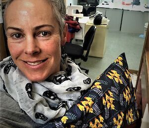 A happy lady holds a hand made pillow