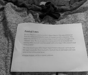 A typed note sits on a pair of repaired pajamas