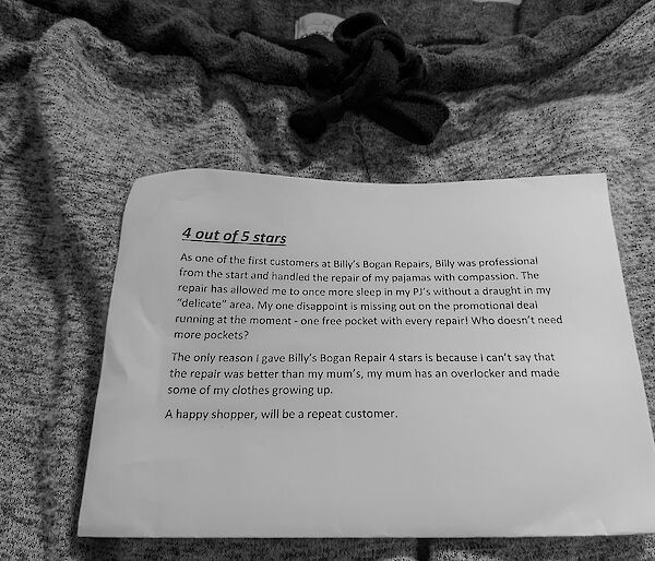 A typed note sits on a pair of repaired pajamas