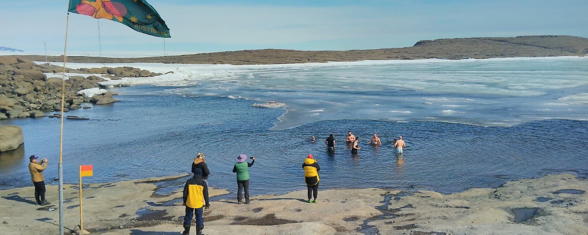 Expeditioners entering the icy water at the Mawson foreshore for the Australia Day swim