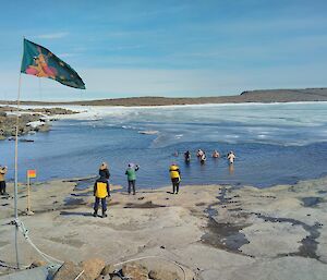 Expeditioners entering the icy water at the Mawson foreshore for the Australia Day swim