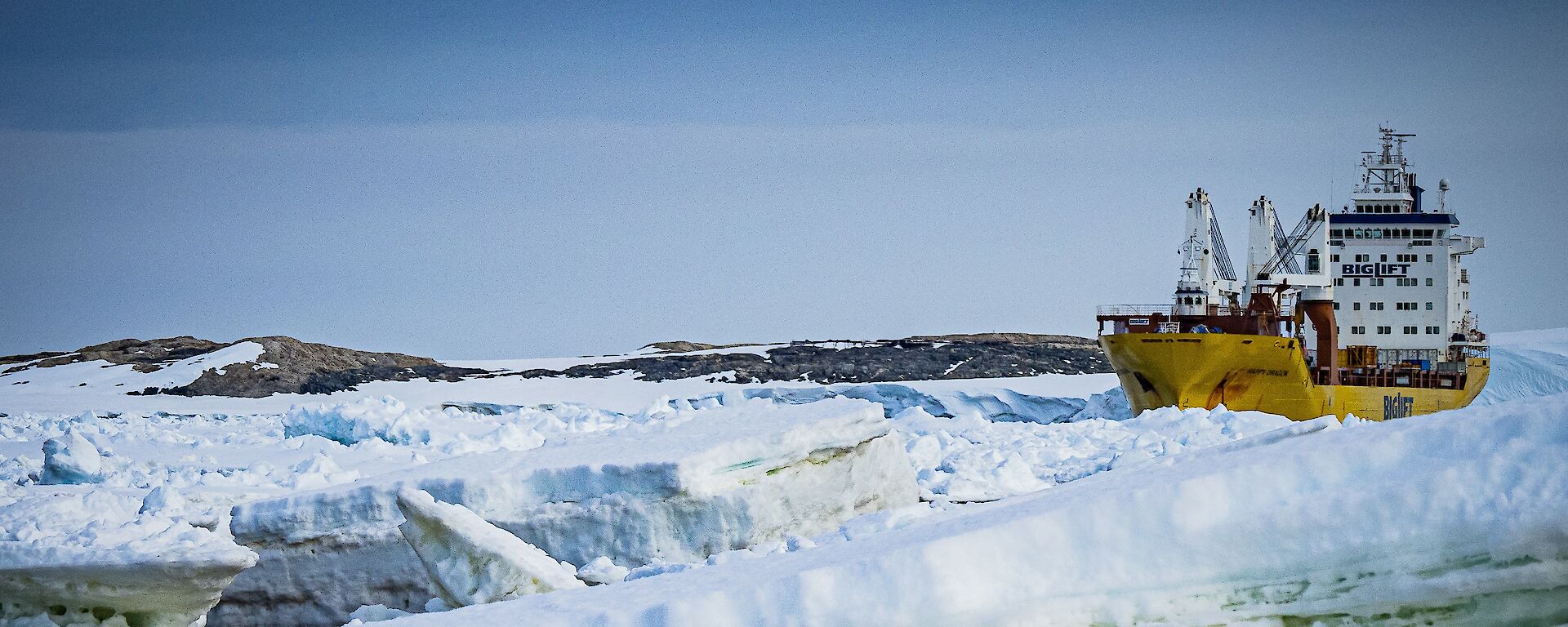 A cargo transport ship, surrounded by large chunks of sea ice