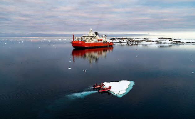 small boats push small ice berg