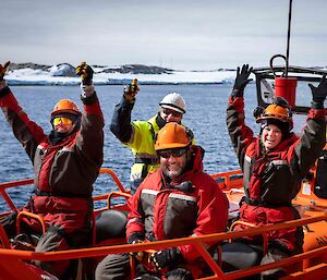 excited people in small boat lowered from ship