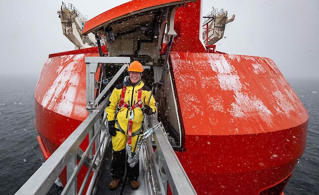 man stands on gantry from bow of ship