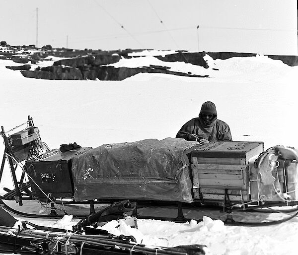 man with sledge in snow, black-and-white photo