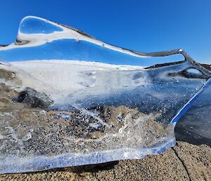 A large piece of ice sitting on a rock