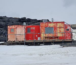 A red hut in the snow and rocky area