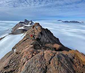 A view to the north with two expeditioners on the long ridge of Mt Elliot and Fang Peak and Parsons Peak in the background