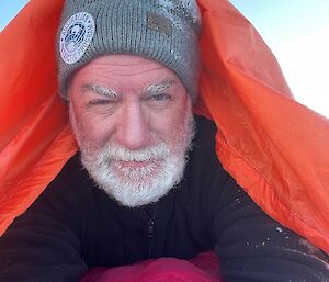 A close up of a person in a red bivvy bag