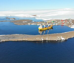 The cargo ship with Mawson station and the Antarctic plateau in the distance