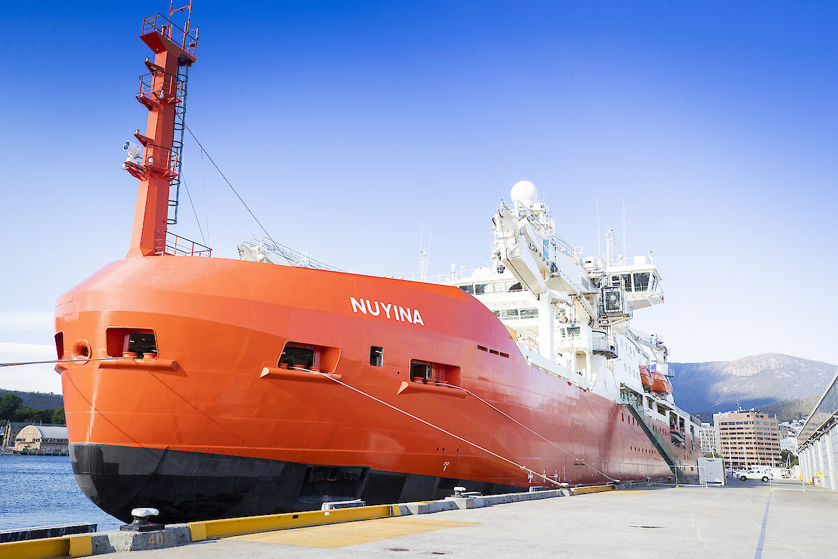 orange ship at mooring in port
