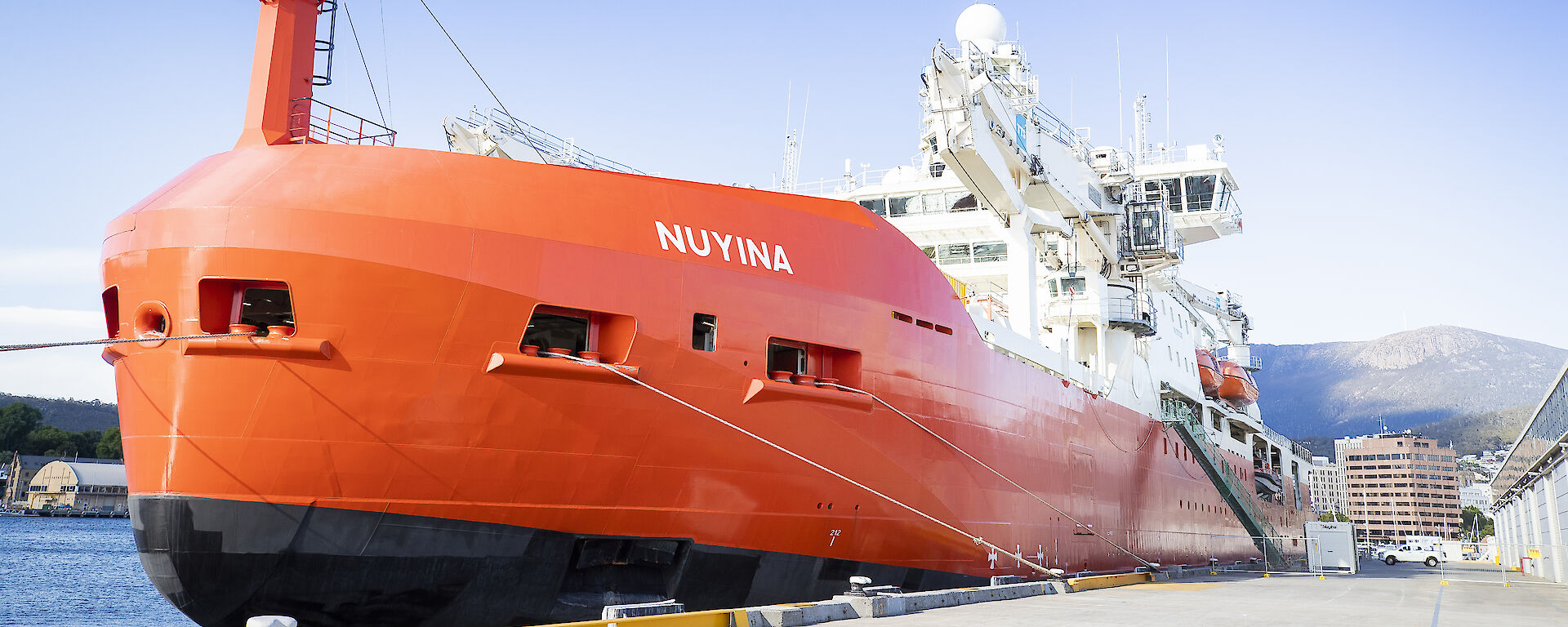 orange ship at mooring in port
