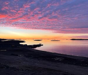 A pink sunset over the beach and water at Davis