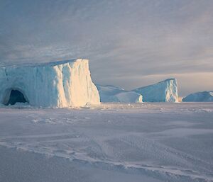 Ice bergs with caves surrounded by sea ice