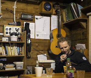 A man in a wooden hut uses the radio to talk back to station