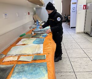 An artist in warm weather gear working on her pieces in Antarctica