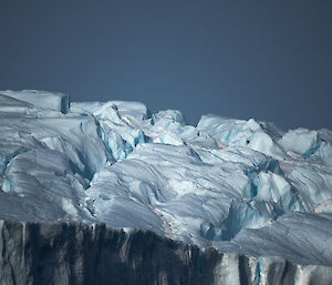 Close up of iceberg with rough surface and many colour variations of bright blue and white