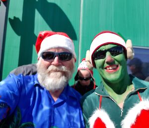 Two men in santa hats and sunglasses