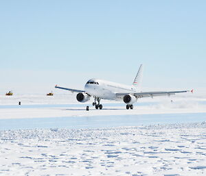 A white plane lands on an ice runway