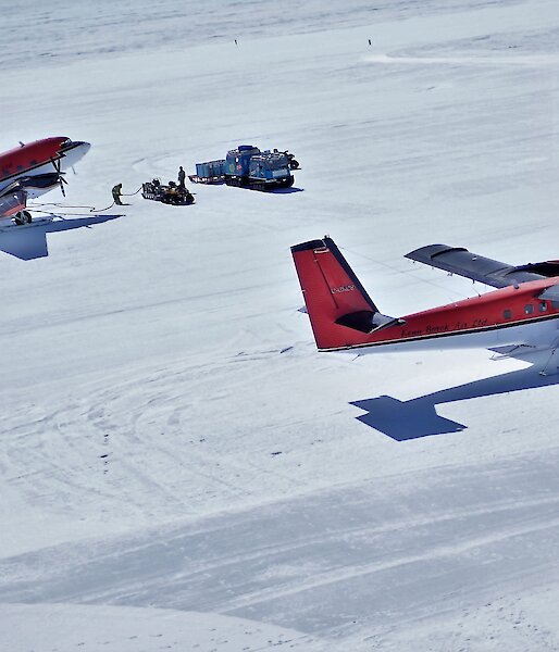 Two red planes parked on the ice
