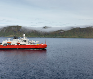 Australia's ice breaker RSV Nuyina sailing past Macquarie Island covered in low cloud