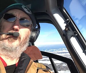 A man taking a selfie in a helicopter over the Vestfold Hills