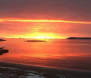 Orange and red sunset with a cloudy sky over the sea