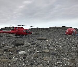 A helicopter and an apple shaped shelter on rocks