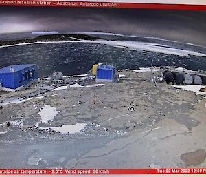 Harbour in middle picture now free of any sea-ice, in the foreground rocky land and two blue buildings and a fuel farm