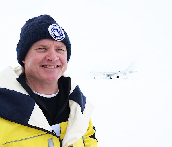 A man in a yellow jacket and beanie in Antarctica