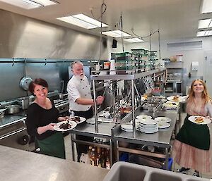 Two waitresses and the chef in the kitchen