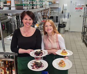 Two waitresses with 2 plates of food each