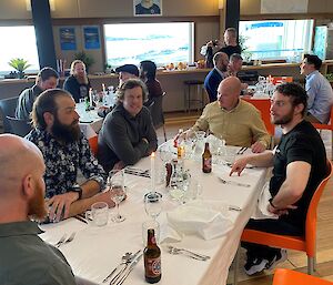 A couple of groups of people sitting at dinner tables