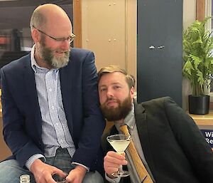 Two men sitting together at a formal dinner