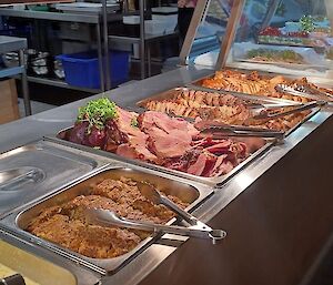 A selection of hot foods like ham and turkey in bain marie