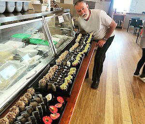A chef with trays of sushi