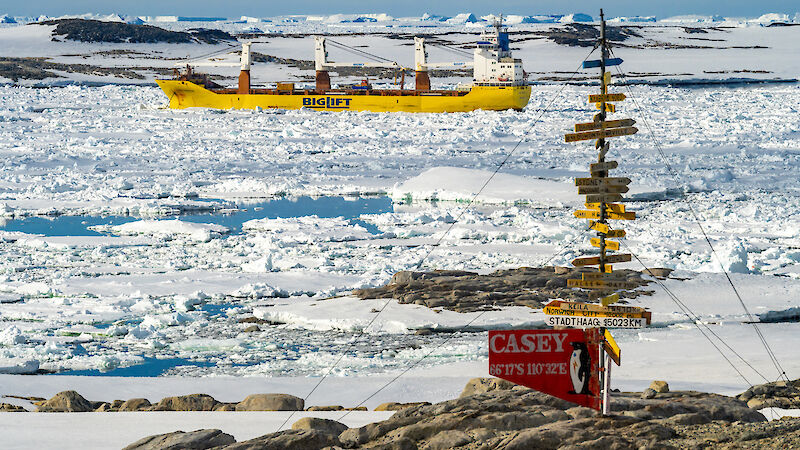 A yellow ship behind a sign post