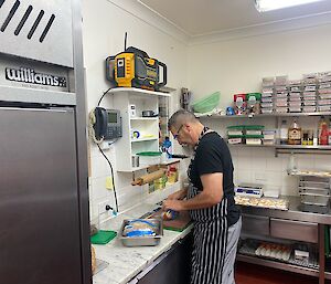 Chef at work in the kitchen in a stripey apron