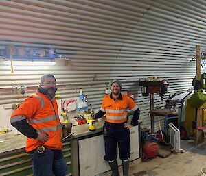 Plumbers at workshop surrounded by equipment