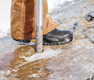 A metal pipe bores into an Antarctic rock