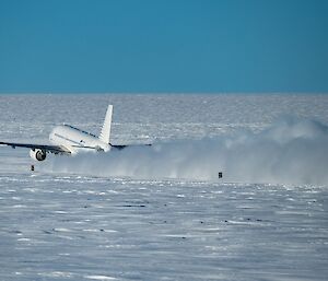 The A319 plane starting its take-off from an ice runway, raising a long plume of snow behind it