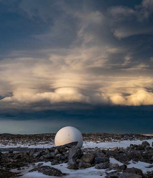 A towering cloud formation in the sky, appearing as flat layers rising from a fluffy base, widening out on top, with a nebulous column rising through the middle