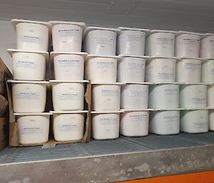 Lots of tubs of ice cream in a large freezer